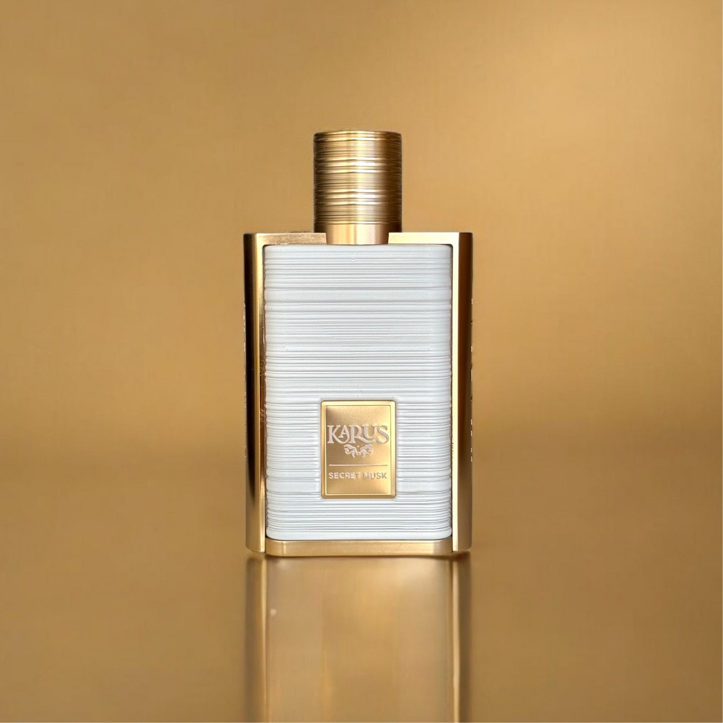 Flacon de parfum luxueux à la forme rectangulaire avec une finition texturée blanche et des bordures dorées élégantes. Un carré doré au centre affiche le nom 'KAPUS' en lettres raffinées. Le bouchon cylindrique doré complète le design sophistiqué. L’arrière-plan doré et la surface réfléchissante renforcent l’esthétique premium du produit