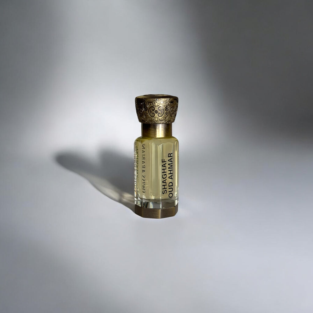 Flacon de parfum raffiné et compact, en verre transparent révélant un liquide doré. L’étiquette porte le nom 'SHAGHAF OUD AMBER' en lettres élégantes. Le bouchon doré finement gravé ajoute une touche sophistiquée. L’éclairage subtil et l’ombre projetée sur le fond clair accentuent son allure luxueuse. Ce parfum fruité est idéal pour un usage quotidien, occasionnel ou formel, et convient particulièrement aux saisons d'automne, de printemps et d'été.
